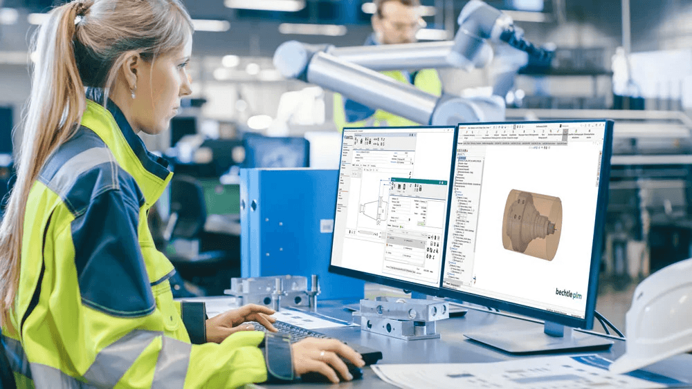 Frau in Fabrik am PC – CNC-Fertigung Eine Frau arbeitet in einer Fertigungshalle am PC zur Steuerung eines CNC-Prozesses