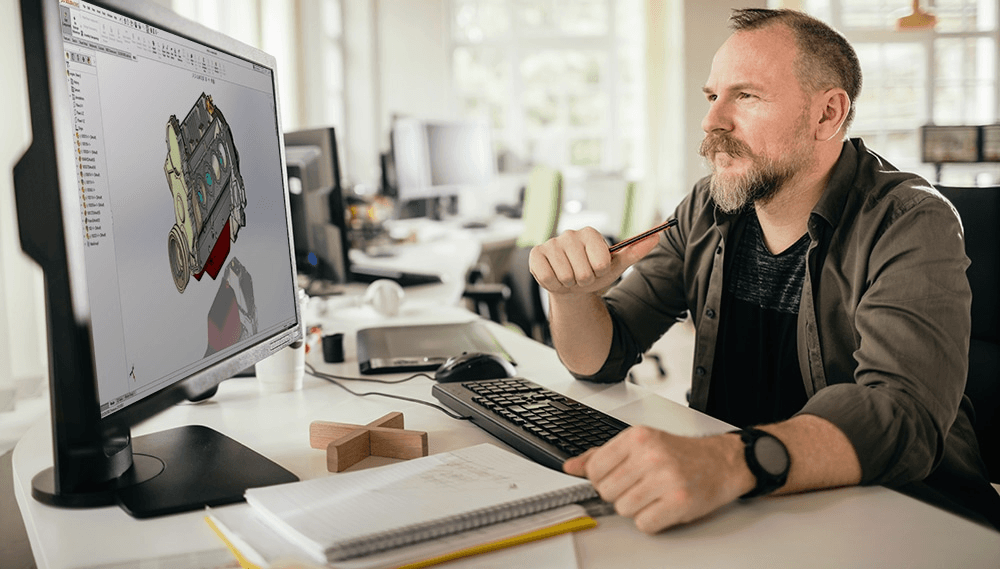 Mann sitzt am Schreibtisch mit Computer
